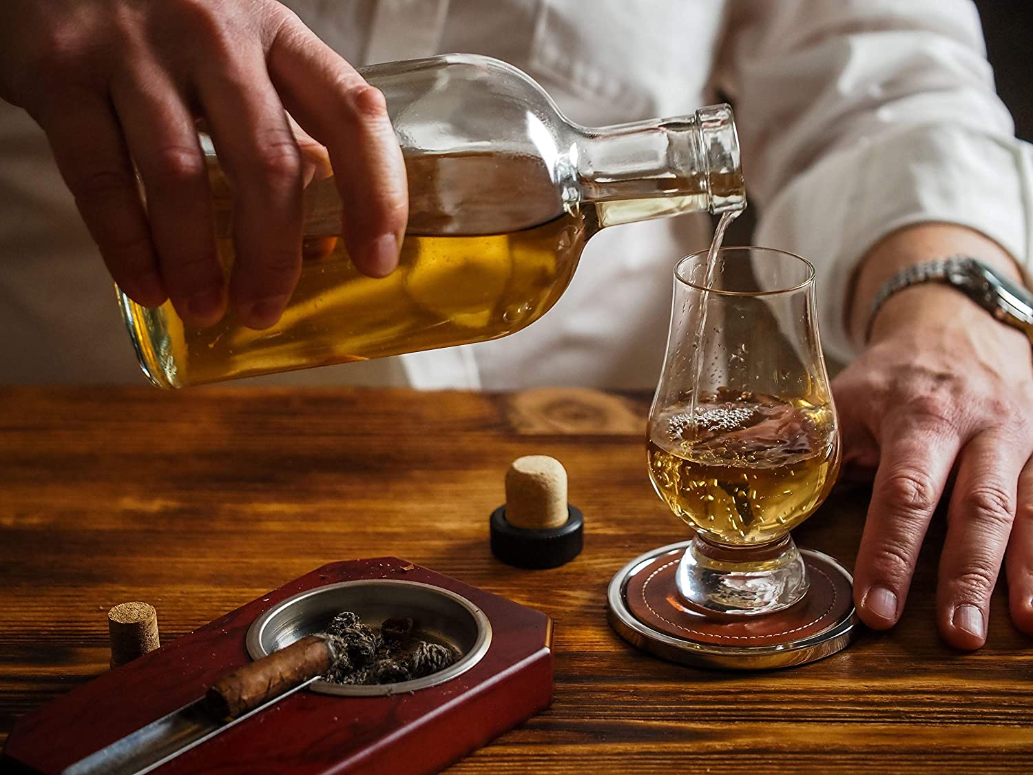 Premium Photo  Pouring whisky from a jigger into a rocks glass with a big  ice cube